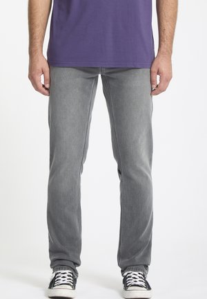 Gray denim jeans with a straight cut, featuring front pockets, minimal fading, and slight distressing at the seams. Worn with black sneakers.