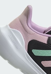 Baskets en mesh rose clair avec des accents noirs, semelle Cloudfoam blanche et bandes pailletées vertes sur le côté, présentant un design de tige texturé.