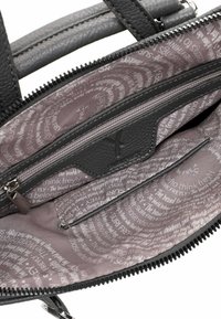 Svart läderhandväska med dubbla handtag, utrustad med dragkedja och ett grått mönstrat inre fodrat med inspirerande text. Inre fickor synliga.