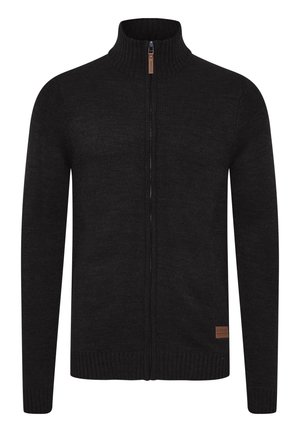 Zwarte ritscardigan van gestructureerde brei stof. Heeft een hoge kraag en ribgebreide manchetten en zoom. Inclusief een klein leren merklabel.
