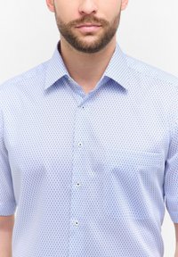 Kurzarmhemd in Himmelblau mit strukturiertem Muster, mit Kentkragen und fünf Knöpfen, aus gewebtem Stoff gefertigt.