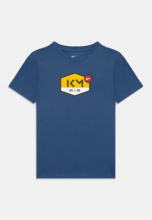 Blaues Baumwoll-T-Shirt mit einem gelb- und schwarzfarbenen hexagonalen "KM AIR"-Logo und einem roten Nike-Swoosh. Klassischer Rundhalsausschnitt und kurze Ärmel.