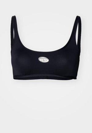 Čierny športový podprsenka so zaobleným výstrihom, tenkými ramienkami a malým strieborným logom v strede. Vyrobená z hladkej, elastickej látky.