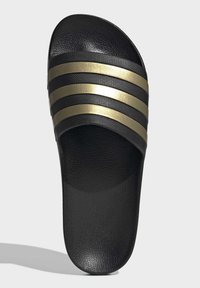 Black slide sandal with three horizontal gold stripes, textured upper, smooth sole, and open toe design.