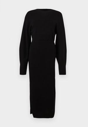 Vestito in maglia nera a maniche lunghe, corpetto aderente, scollo tondo, materiale elastico, spacco laterale sull'orlo per facilitare i movimenti.