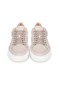 Sneakers beige chiaro con una morbida texture in suede, punta arrotondata, suola in gomma bianca a contrasto e lacci piatti. Design minimalista senza branding visibile.