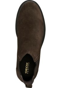 Zapato marrón de ante con paneles elásticos en los laterales, punta redonda y suela de goma. Presenta la marca "GEOX RESPIRA" en la plantilla.