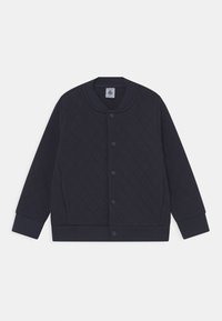 Marinblå vadderad jacka med tryckknappar, ribbade ärmslut och nederkant, rund halsringning och långa ärmar, liggande på vit bakgrund.