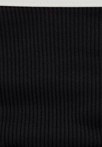 Tissu en tricot noir à côtes avec des rayures texturées verticales et une couture ou un bord blanc en haut.