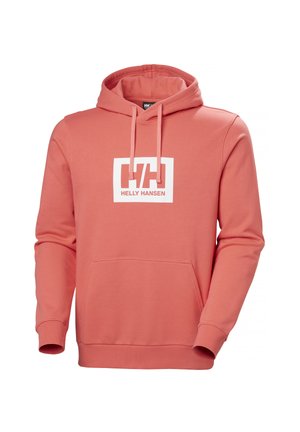 Bluza z kapturem w kolorze koralowym z przednią kieszenią, sznurkami oraz białym logo Helly Hansen umieszczonym centralnie na klatce piersiowej.