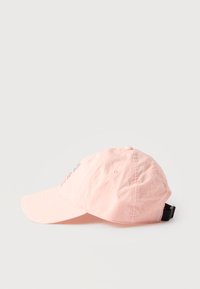 Ανοιχτό ροζ καπέλο μπέιζμπολ με κεντητό λουλουδάτο σχέδιο στο μπροστινό μέρος και μαύρο ρυθμιζόμενο λουράκι στο πίσω μέρος, εμφανιζόμενο από την αριστερή πλευρά.