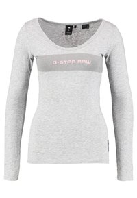 Světle šedé tričko s dlouhým rukávem z bavlny s kulatým výstřihem. Na přední straně se nachází šedý pruh s nápisem "G-STAR RAW" v růžovém textu.