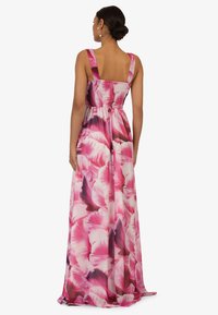 Maxikleid mit angepasstem Oberteil und breiten Trägern, das ein Blumenmuster in Rosa- und lila Tönen aufweist. Fließender, leichter Stoff mit glatter Textur.