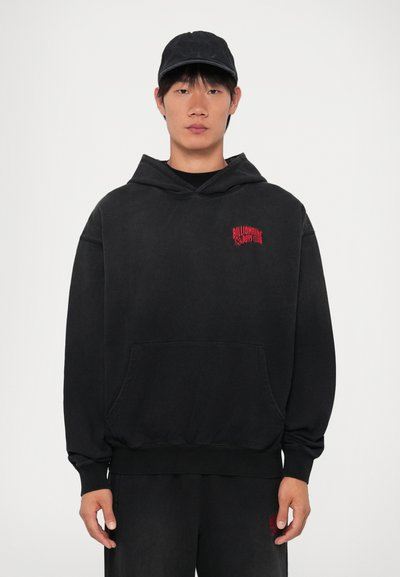 Sudadera con capucha negra y un bolsillo frontal. Presenta el texto bordado en rojo "BILLIONAIRE BOYS CLUB" en el lado izquierdo. Material suave.