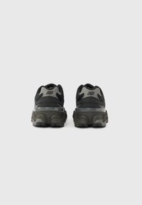 Black and gray athletic shoes with a textured upper, curved midsole, and distinct heel design. Features branding on the back.