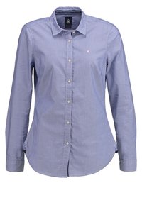 Camicia a maniche lunghe a righe blu, con colletto, apertura con bottoni e un piccolo logo. Presenta un orlo curvo e un tessuto interno a contrasto sui polsini.