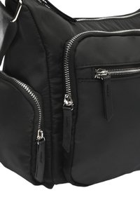 Schwarze Nylon-Tasche mit mehreren Reißverschlussfächern. Hat ein elegantes Design, strukturierten Stoff und silberne Hardware-Akzente an den Reißverschlüssen.