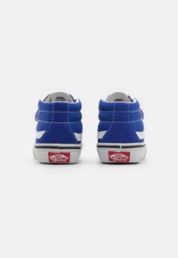 Zapatillas altas de ante azul con acentos blancos, franja media negra y logo rojo "Off the Wall" en el talón. Detalle de costura en los lados.