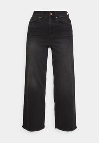 Černé denimové kalhoty s širokými nohavicemi a vysokým pasem, měděným knoflíkem a roztrhaným lemem. Obsahují pět kapes a mají hladkou strukturu.