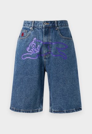Denim shorts in blue with a loose fit. Features a purple cartoon cat graphic on the front and a red patch on the waistband.