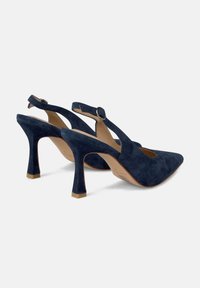 Talons hauts slingback en suède bleu marine avec un bout pointu, un talon fin et une boucle décorative. Matériau texturé avec une doublure intérieure lisse.