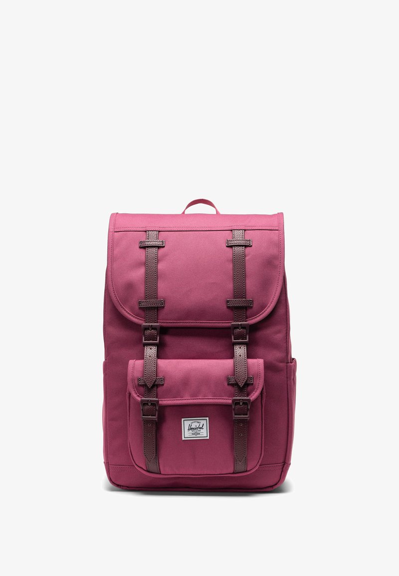 Zaino in tela bordeaux con spallacci in pelle marrone, un pattino superiore e una tasca frontale. Presenta un'etichetta del marchio sulla parte anteriore inferiore.