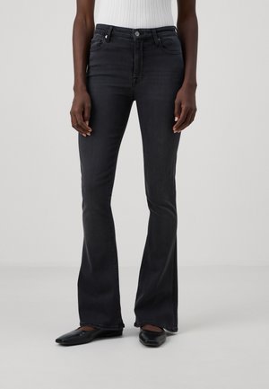 Hochtaillierte schwarze Denim-Jeans mit Schlag verfügen über eine gestickte Detailgestaltung und das klassische Fünf-Taschen-Design, kombiniert mit schwarzen, spitzen Ballerinas.