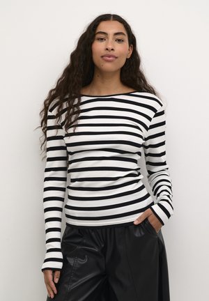 Black and white striped long-sleeve fitted top, crew neckline, ribbed texture, paired with loose black pants.