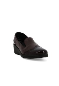 Scarpa slip-on in pelle marrone scuro con tacco a zeppa basso e perforazioni decorative sulla punta, leggermente inclinata verso destra su sfondo bianco.