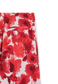 Blumenhose mit weißem Hintergrund, versehen mit großen roten und dunkelpinken Blüten. Enthält eine offene Gesäßtasche.