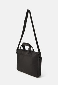Sort nylon messenger taske med to top-håndtag og en justerbar skulderrem. Den har en lynlåslukning og en glat, holdbar tekstur.