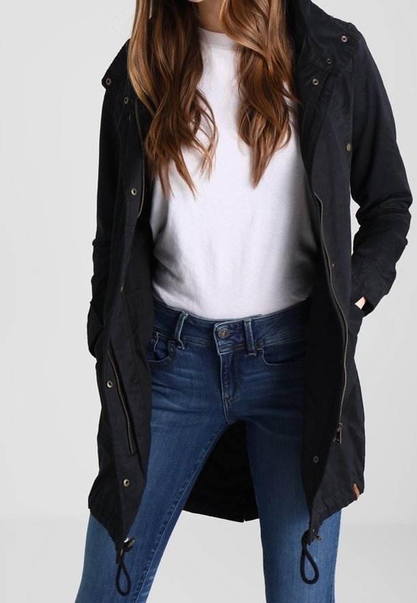 Černý dlouhý kabát s kapucí, zapínání na zip, stahovací pas a kapsy. Nosit s bílou košilí a modrými džíny, hladká textura.