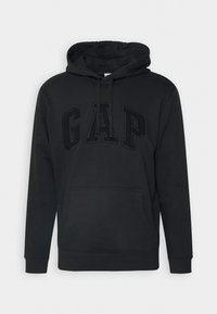 Svart hoodie med framficka, dragsko i huvan och präglad "GAP"-logotyp över bröstet, visad mot vit bakgrund.
