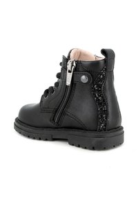 Stivale alla caviglia in pelle nera con lacci frontali, zip laterale e dettagli glitterati sul retro. Punta rotonda e suola in gomma testurizzata.
