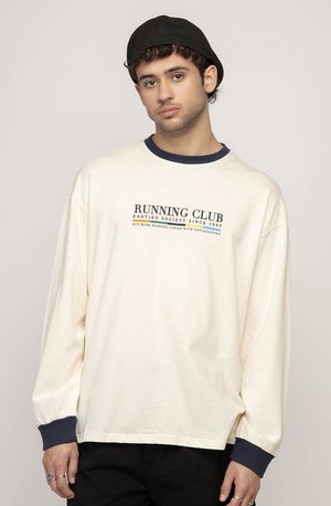 Cream long-sleeve t-shirt with navy collar and cuffs, featuring "RUNNING CLUB" graphic in dark blue. Cotton fabric, relaxed fit.