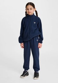 Marinblå fleeceträningsoverall med jacka med dragkedja och byxor med elastisk midja, med en liten logga på bröstet och sidan av benet.