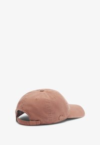 Gorra de suave algodón cepillado en color rosa pálido, con corona redondeada, visera curvada y correa ajustable con un acento de logo en la parte trasera.