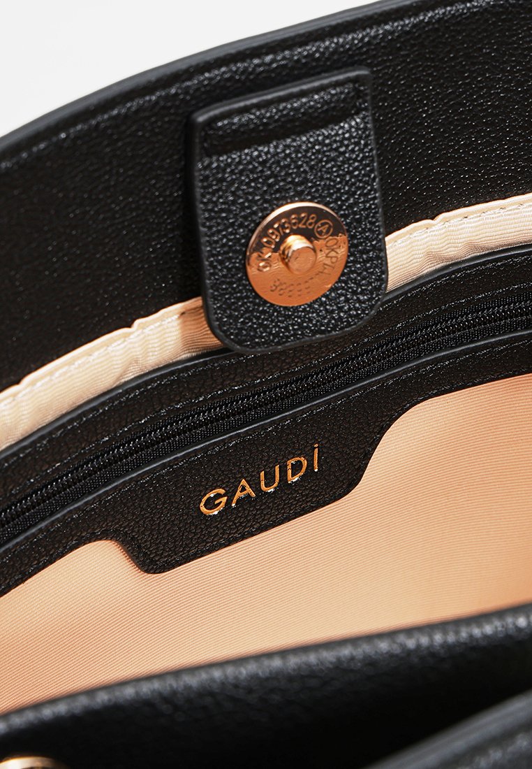 Interno della borsa nera textured con fodera beige. Presenta un logo dorato "GAUDI", una tasca con zip e una chiusura a scatto.