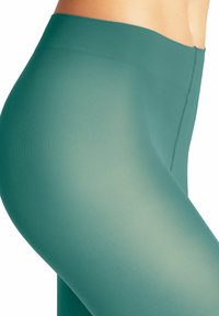 Leggings taille haute, sans couture, dans une couleur bleu-vert atténuée. Fabriqués à partir d'un tissu lisse et extensible avec une texture côtelée et un éclat subtil.