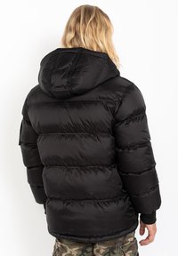 Sort dunjakke med hætte, der har et quiltet design, glat tekstur og elastiske manchetter, med en lige pasform og ingen synlige lukninger.