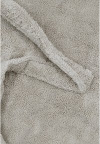 Šviesiai pilka pūkuota medžiaga su minkštu, tekstūruotu paviršiumi; turi pasuktas kraštus ir jaukią, kviečiančią išvaizdą.