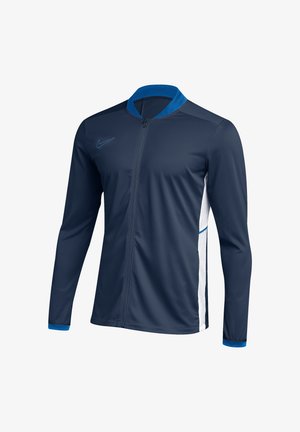 Dunkelblaue Sportjacke mit durchgehendem Reißverschluss, langen Ärmeln, hellblauem Kragen und Bündchen, weißen Seitenpartien und kleinem Swoosh-Logo auf der Brust.