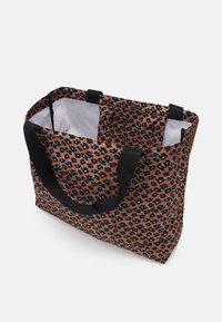 Sac fourre-tout à motif floral en orange, noir et bleu, avec des poignées noires, un haut ouvert et un intérieur spacieux doublé de blanc.