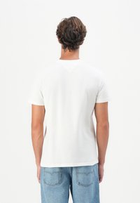 Hvid bomulds t-shirt med rund hals, korte ærmer og lige kant. Bagsiden har en subtil sømdetalje og ingen synlige logoer.
