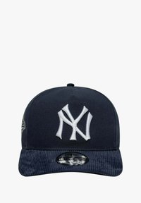 Laivastonsininen lippalakki, jossa valkoinen kirjailtu "NY"-logo edessä, samettivanne ja säädettävä hihna takana.