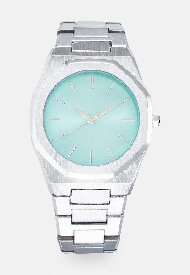 Silver octagonal watch with a light turquoise dial, minimalist silver hands, and hour markers. Metallic link bracelet with brushed texture.
