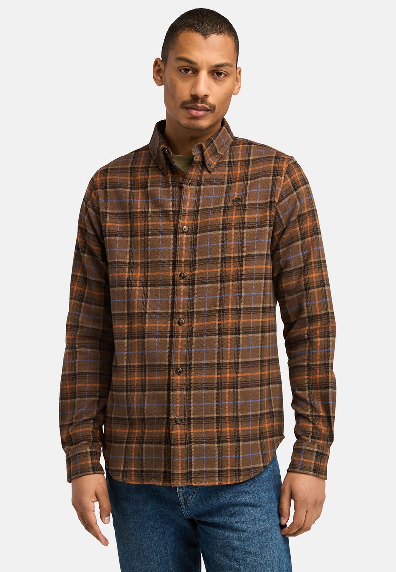 Button-up flanellen shirt in bruin met oranje en blauwe ruitpatronen. Beschikt over een kraag, lange mouwen en een afgeronde zoom. Zachte stoftextuur.