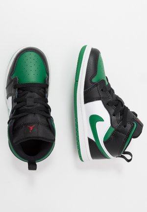 Para czarno-zielono-białych sneakersów typu high-top z czarnymi sznurowadłami, zielonym logo Nike Swoosh i czerwonym logo Jumpman na czarnym języku.