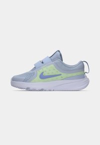 Chaussure de sport bleu clair avec une tige en maille, des accents verts, une sangle en velcro et une semelle texturée. Présente un logo Nike violet.