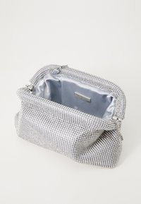 Sac de soirée en argent recouvert de strass, avec un design plissé et une doublure en satin. Fermeture zippée avec quincaillerie métallique.
